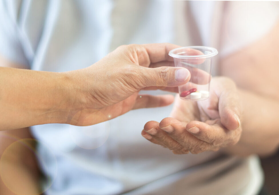 Geriatric doctor or geriatrician concept. Doctor physician hand on happy elderly senior patient to comfort in hospital examination room or hospice nursing home or wellbeing county.