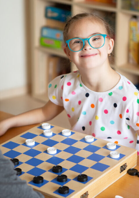 Girl with Down Syndrome Plays Checkers with Her Sister in Quarantine