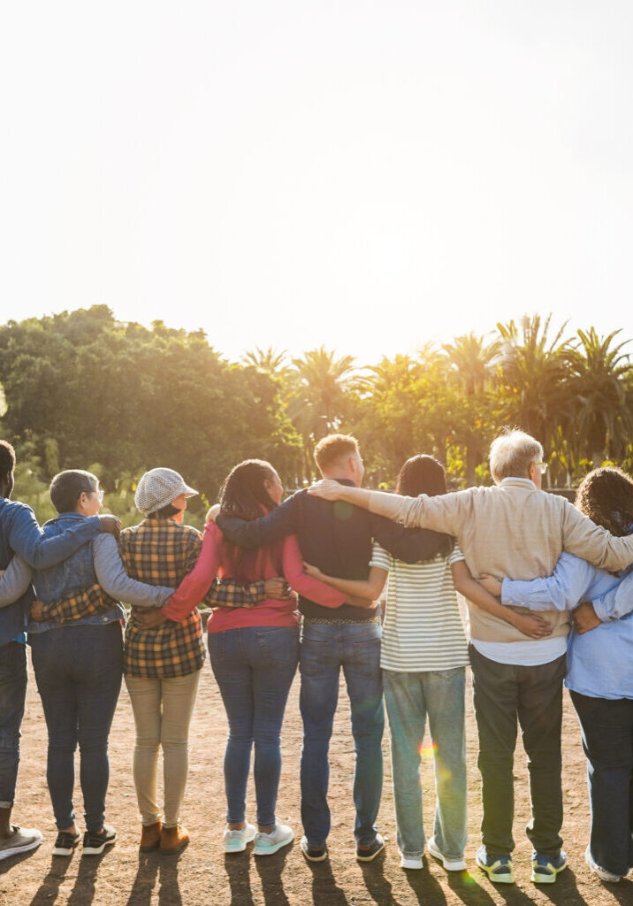 Group of multigenerational people hugging each others - Support, multiracial and diversity concept - Main focus on senior man with white hairs